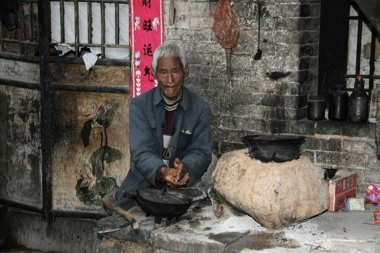 这位老人是个孤寡老人,从地里干活回来洗手准备做饭,在房门前大灶台上