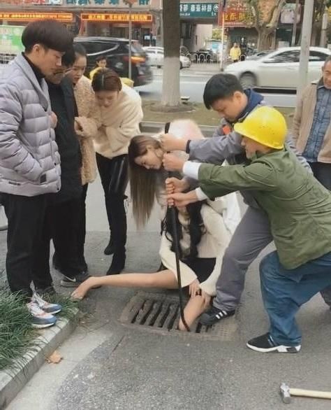 美女走路玩手机,不幸掉进下水道井盖,网友:身材太好有