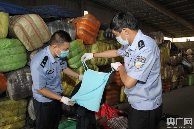 厦门海关缉私警察在展示查获的走私进境韩国旧衣服(雷国华摄)