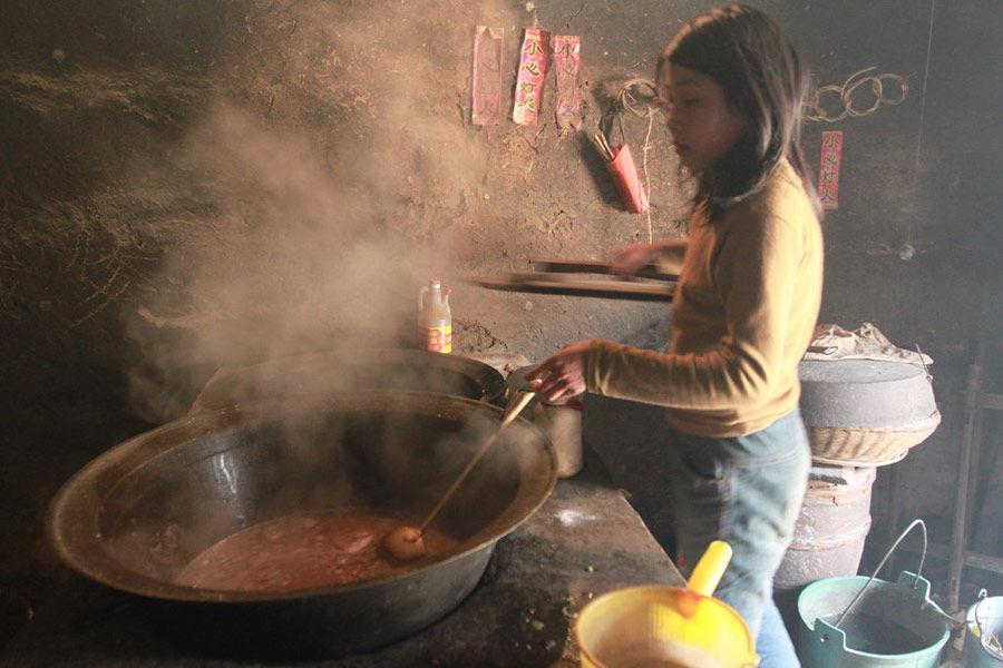 图中是大女儿,她正在给自己的一家人做饭.