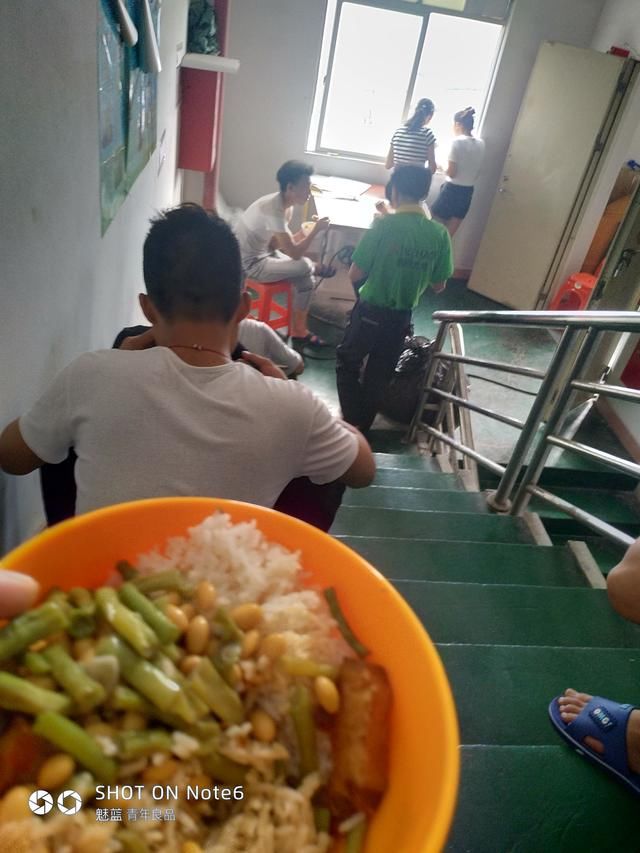 (图)工厂里面的饭菜 工人们正在吃饭他们就坐在楼梯边上吃饭.