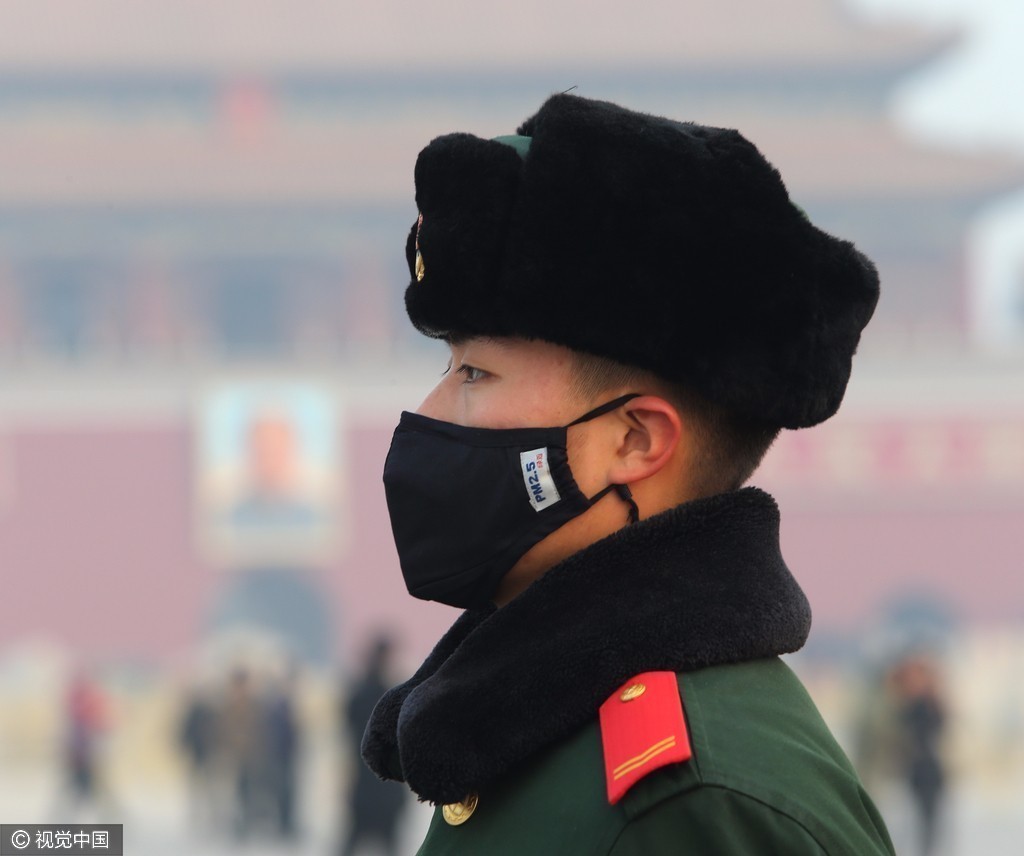 北京:雾霾持续 武警战士戴口罩在天安门广场值勤