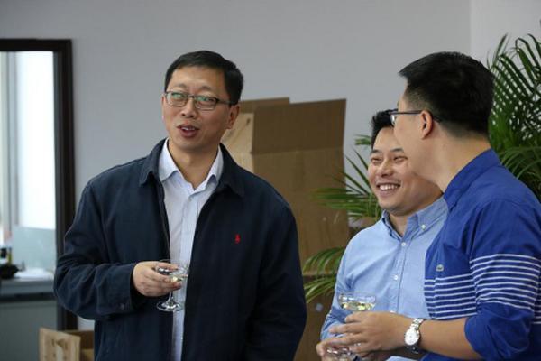 (从左往右:决胜网cfo龙明,决胜股份ceo阙登峰,决胜网总裁王雷在背景墙