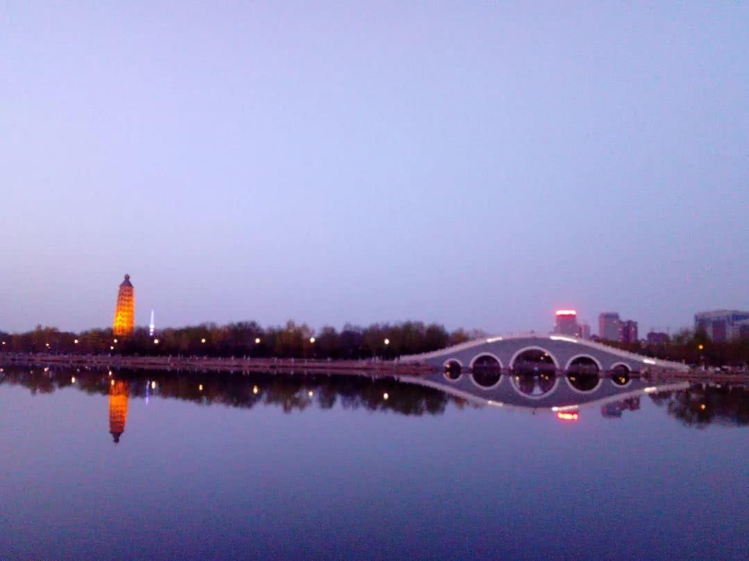 当夜幕降临,夜色中的银川北塔,水天一色,相映成趣.