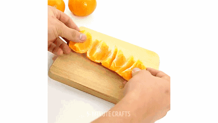 在一边划一刀,从划开的地方往两边剥开,像剥桔子一样把橙子分瓣剥开