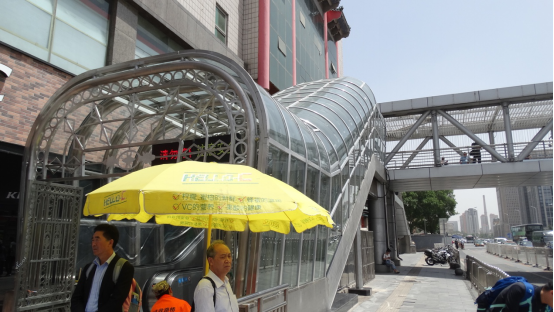 深蓝色的电梯雨棚改为通透的桥面顶棚以及干净透亮的扶梯雨棚,显得