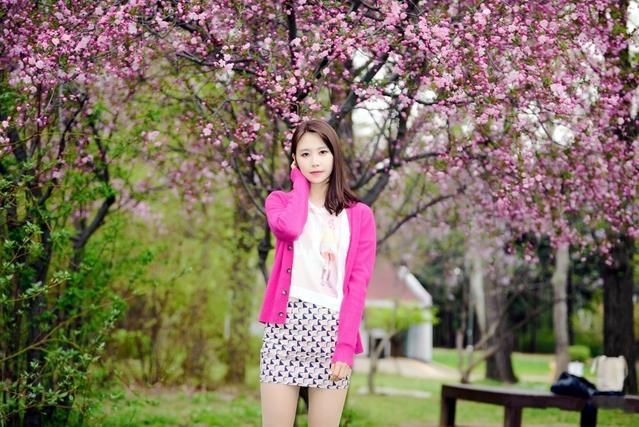 花开公园美景下的靓丽红衣美女