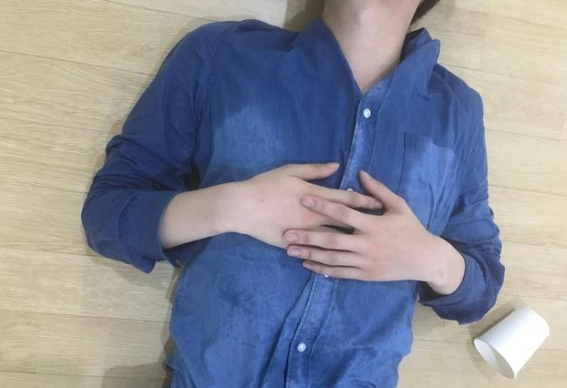 照片中,张艺兴精疲力尽的躺在地板上休息,身穿的蓝色衬衫已被汗水湿透