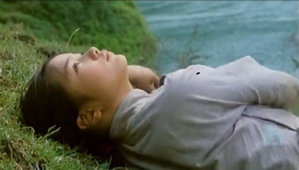 电影《边城》剧照,翠翠躺在草地上,望着天空