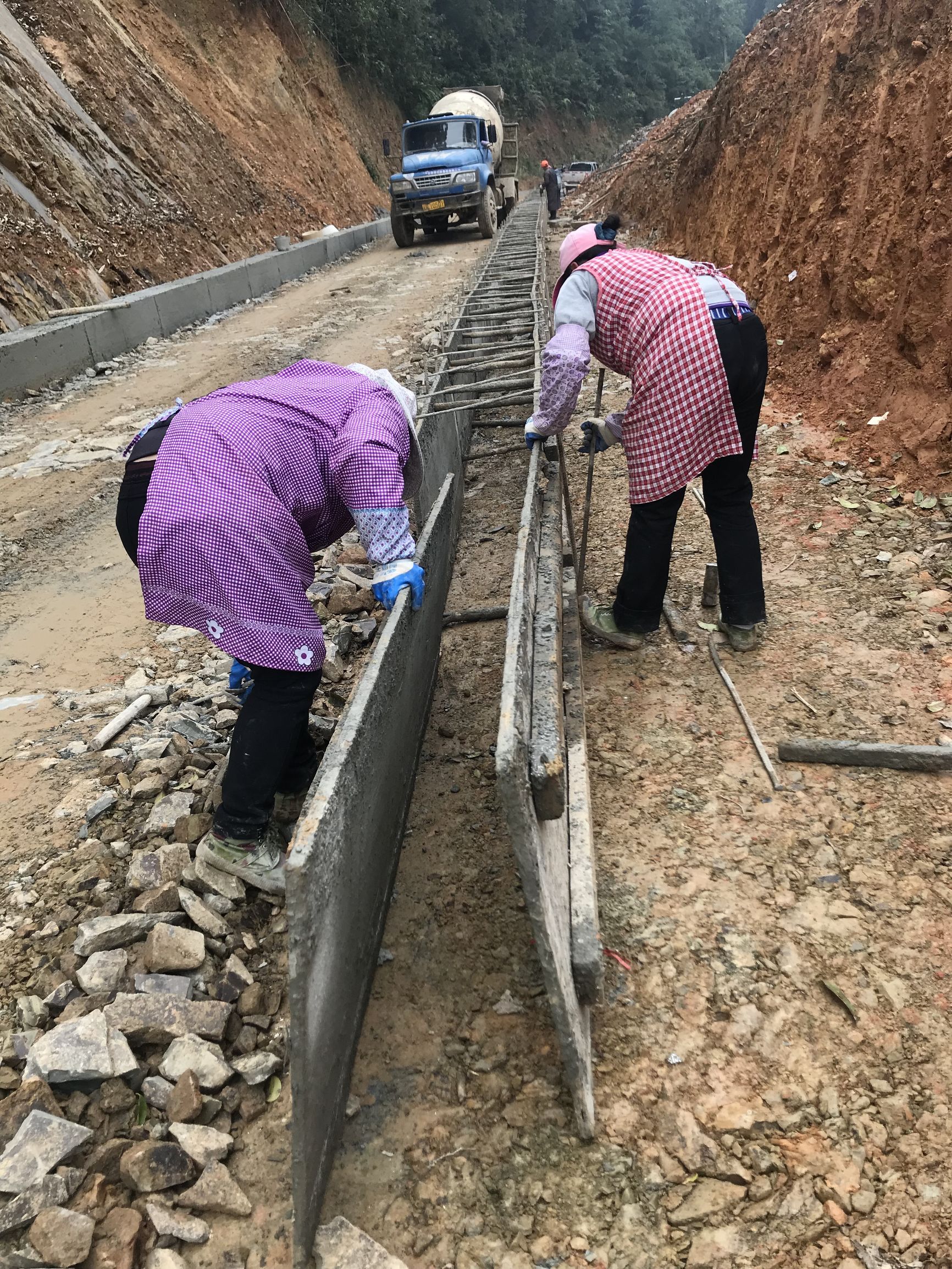 浇灌两条水泥带后用石填满 修筑农村公路貌似很简单