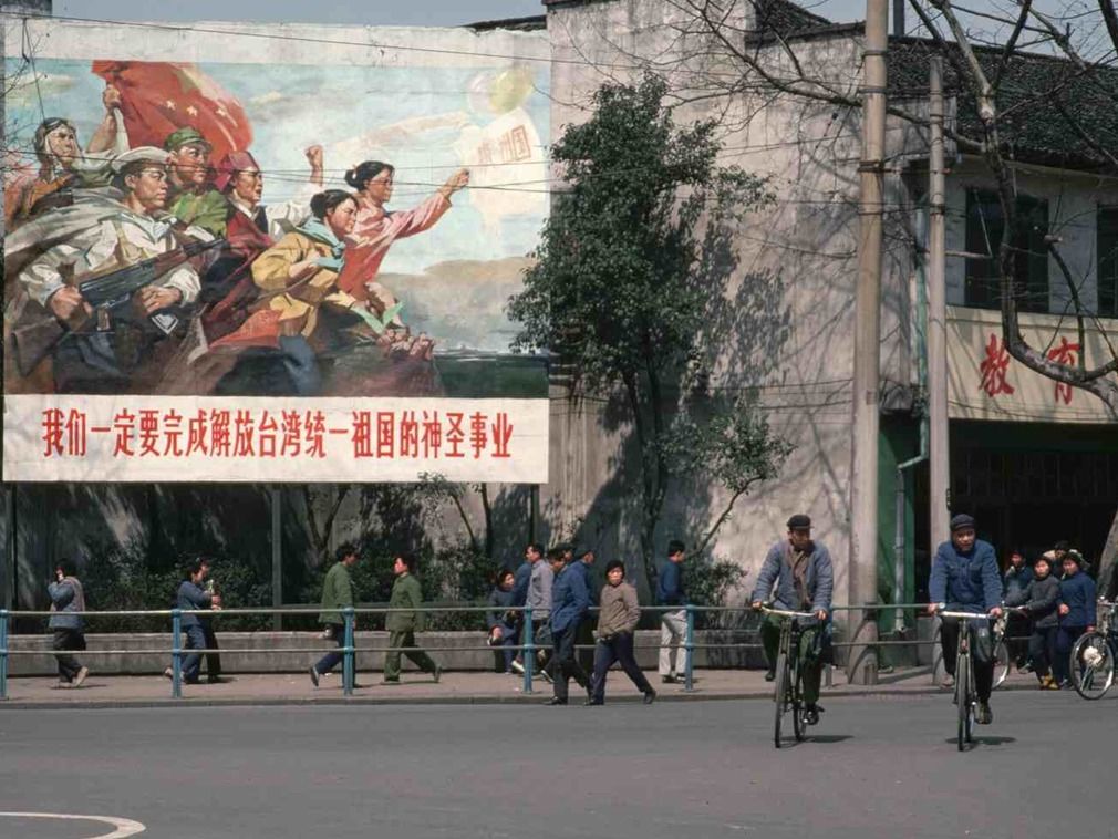 图为在大标语下,骑行的北京市民.