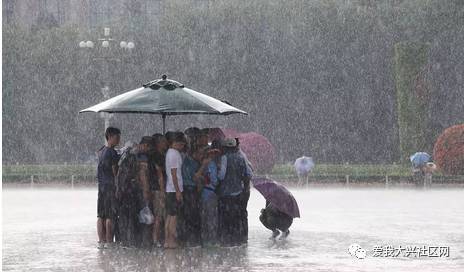 瓢泼大雨中武警和游客共用一把伞. 千龙图像库签约摄影师 赵建洪摄