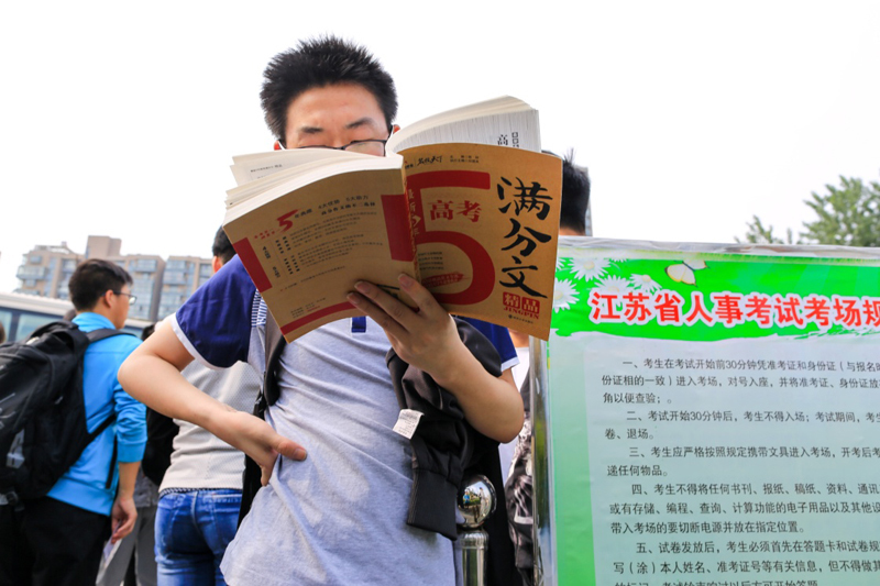 6月7日,在江苏省扬州市仙城中学高考考点,一名考生在候考时抓紧最后