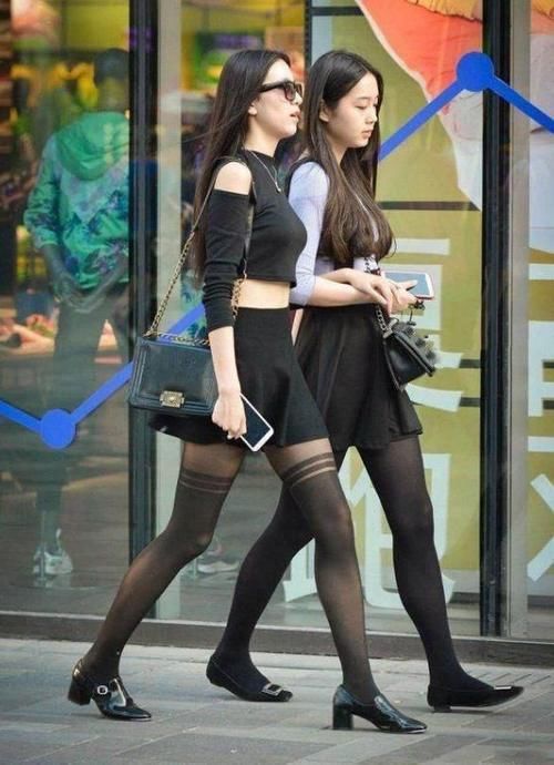 这两美 女同样是穿黑丝袜,设计却不一样,黑色露脐装美女的黑色丝袜有