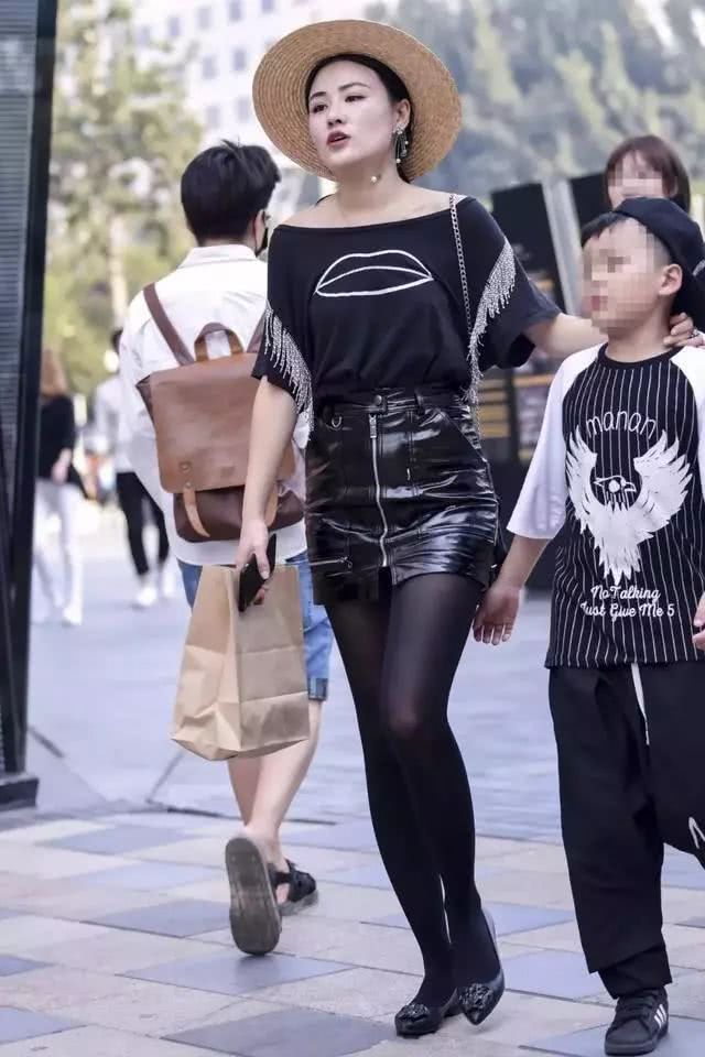 街拍:黑色皮裙巧搭黑丝袜的辣妈,偶尔也玩出点小知性