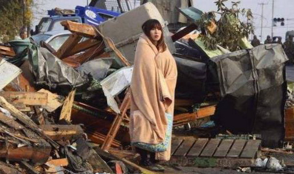 2011年东日本大地震,一名女性灾民在震后现场.图片来源:铁血社区