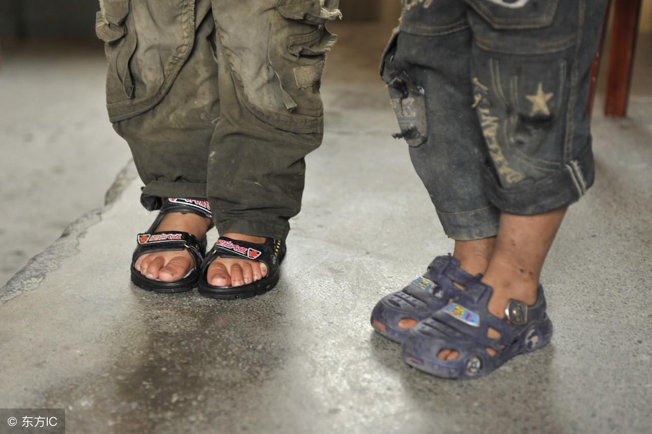 这是农村小孩子的鞋子,衣服也是很破,要是城市孩子才不穿这样的呢.