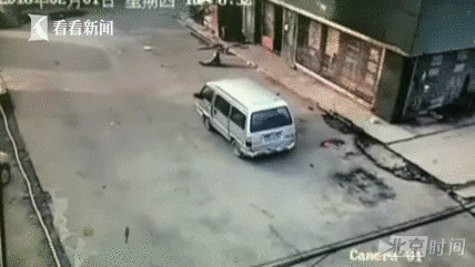 此时,惊魂的一幕发生了,白色面包车突然开始倒车,面包车的右后轮从