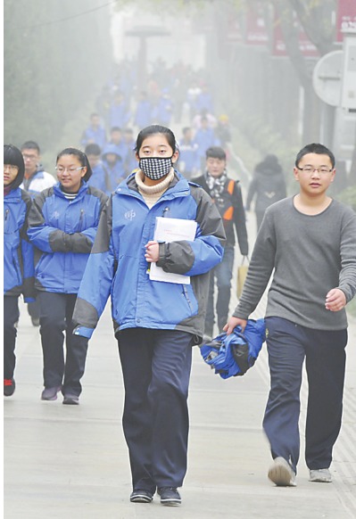 二〇一六年十二月十八日,西安遭遇雾霾天气,街头行人戴口罩出行.