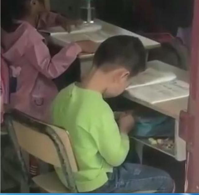 老师上课中发现男孩在搞小动作,准备批评,看到做的事情不忍心了