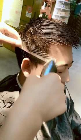 然后用推剪开始给他修剪旁边的头发,要剪短之后才能显得更加的精神