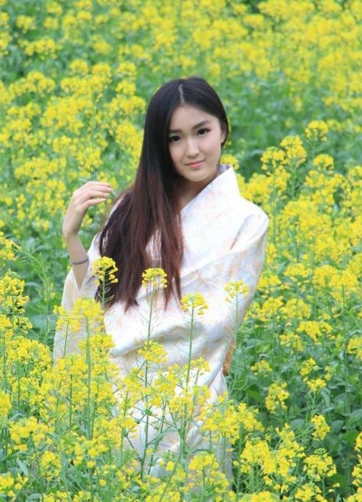 油菜花下的东方佳人风情万种一一所赏曹雕写实主题油画《丛中笑》