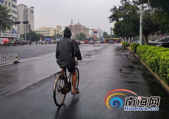 白龙路上市民披雨衣骑车出行.南海网记者 姚皓 摄