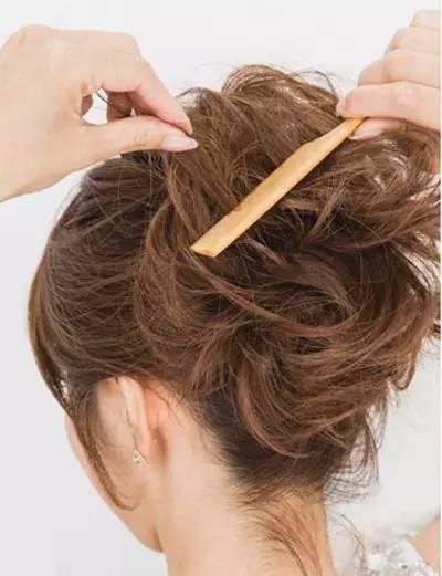 step3:用细齿梳子将所有的头发倒梳倒毛,让脑后的头发看上去随意慵懒.