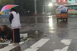温情满满！菜贩雨中捡菜 陌生女孩为其撑伞