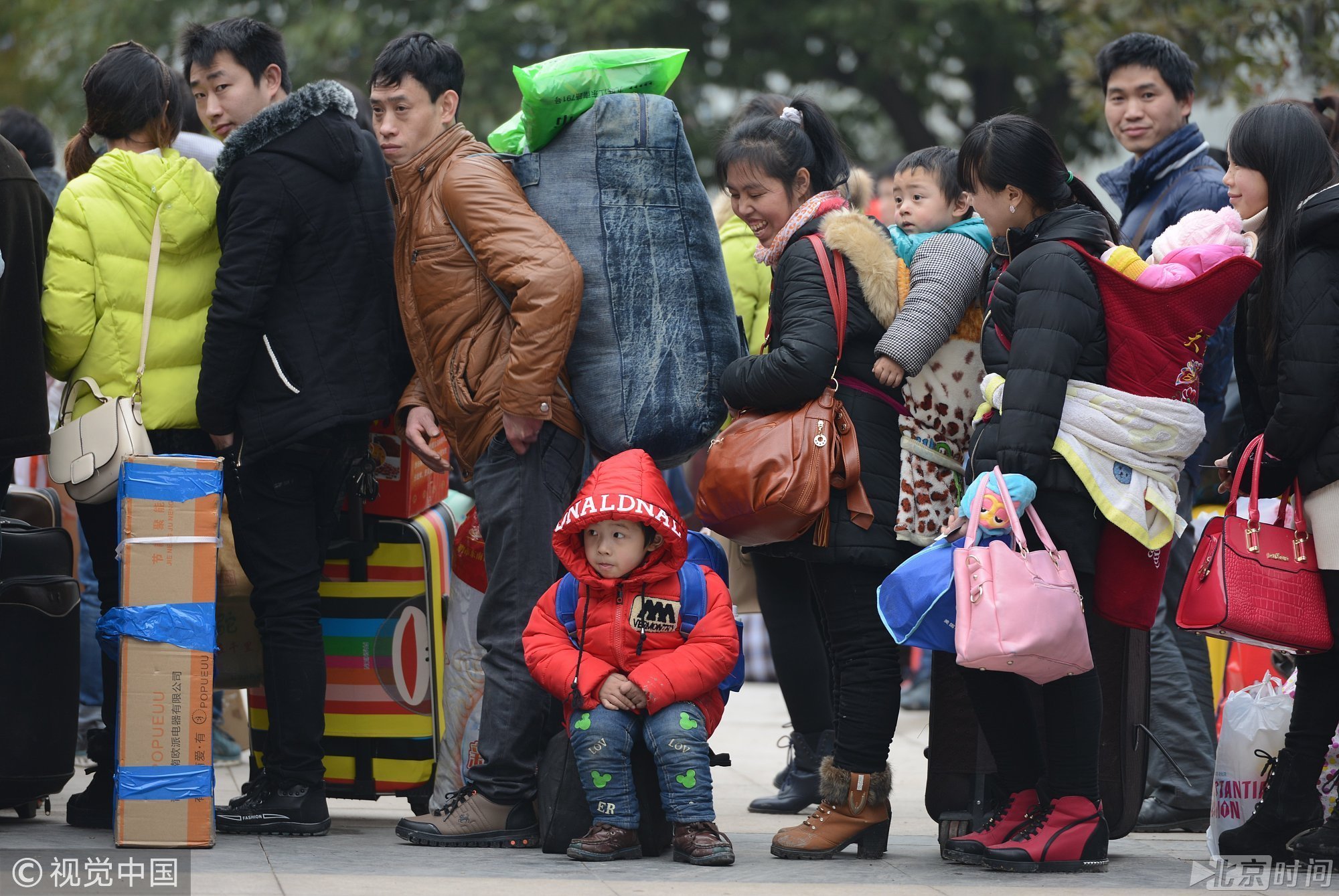 2015年02月04日，浙江金华，春运首日，义乌火车站春运首日发送乘客达22570。等待上车的外来建设者们或背着重重行囊或拖家带口，个个归心似箭。图/视觉中国