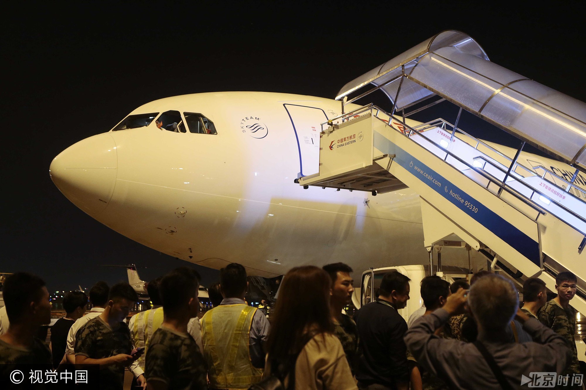 深夜的上海虹桥机场一如平常地灯火通明，人流如鲫。随着两架A330客机先后安全着陆，候机人群爆发出热烈的欢呼声，一面面鲜艳的国旗随手飘扬，成为一道夺目的风景。图/视觉中国