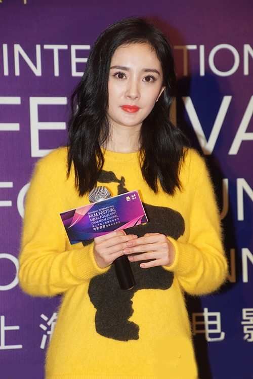 杨幂身着黄色上衣搭配黑色短裙,台上90度鞠躬