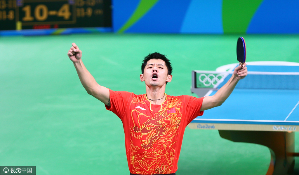 关键的第四局，张继科每得一分，刘国梁就非常激动的从座位上蹦起来欢呼为弟子鼓劲，每一球都会伴随着刘国梁的高喊。很快张继科也被这种气势感染，找回了自己的节奏。8平后张继科手不软，他连赢3分以11比8拿下，总比分追成2平。士气大振的张继科在决胜局以5比3领先交换场地，易边后张继科乘胜追击，他连续得分以10比4拿到场点。随着郑荣植侧身拉球落空，11比4，张继科赢下决胜局以3比2实现翻盘，中国队以1比0领先。图为张继科振臂欢呼。