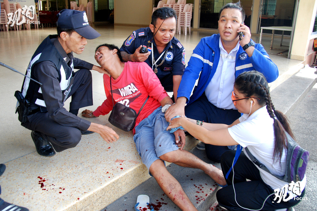 当地时间2016年8月12日报道，泰国当局表示，从8月11日晚至12日上午，泰国著名旅游胜地华欣和南部省份共发生8次炸弹爆炸，目前至少导致4人死亡。英国、澳大利亚在内的多国发布安全提醒，呼吁本国在泰公民，尤其是离爆炸地点较近的人员注意安全。有猜测称此次连环爆炸事件与刚过去的新宪法公投有关。图为炸弹爆炸现场，一名伤者接受救助。