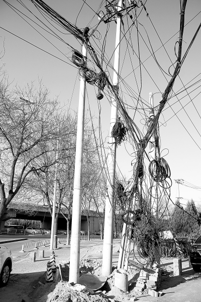 海淀区清河小营桥东北角,电线杆上垂下的缆线乱如麻,既不美观也不安全