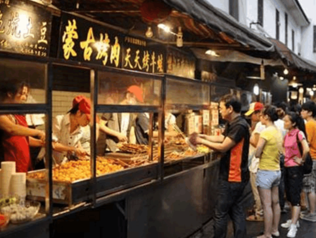 大妈在校门口卖小吃,1元一个,生意真好,手上戴