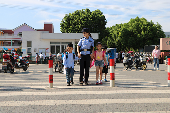 图为在苏州市相城区望亭镇中心小学,民警在"护学岗"上为学生们保驾