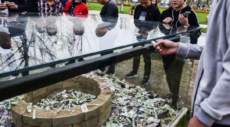 2017年10月12日，西安市刚开放的昆明池·七夕公园里，一个汉代陶井砖的玻璃展示柜里也被游客扔满了钱，其中甚至还有百元大钞。