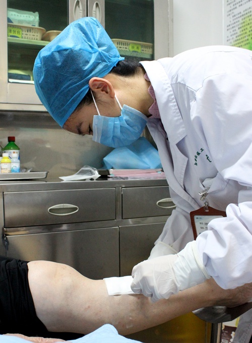 南街街道社区卫生服务中心医生为患者清创换药