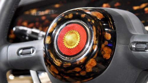 方向盘的向日葵车标非常精致,周围包裹的是高端实木.