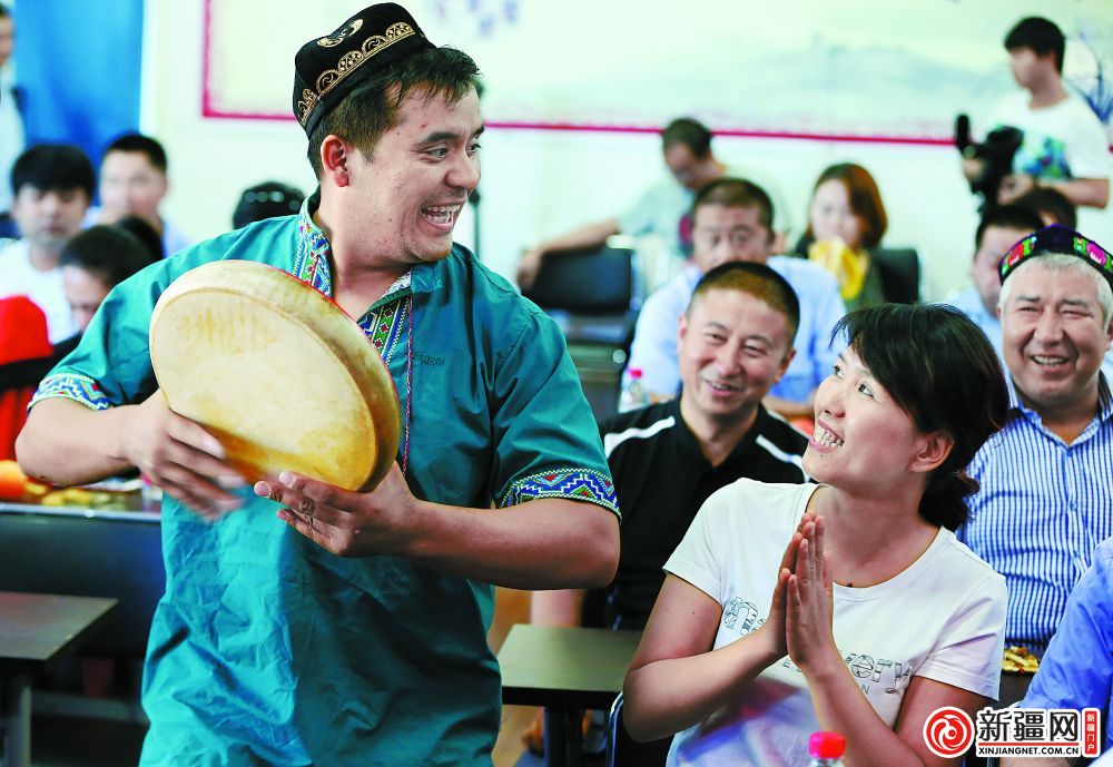在公交集团经营二部礼堂,工作人员希尔艾力·阿西木在为大家演奏手鼓