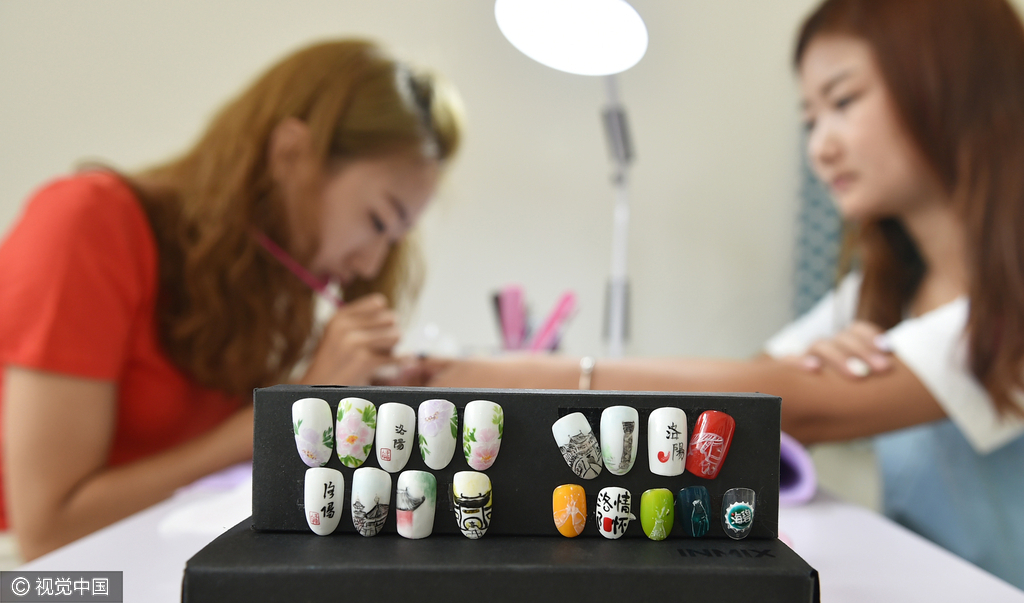 2016年9月3日，河南洛阳，90后美甲师李雯芳在指甲模上绘制的“洛阳白马寺”、“洛阳古建筑”及“洛阳牡丹”图案。