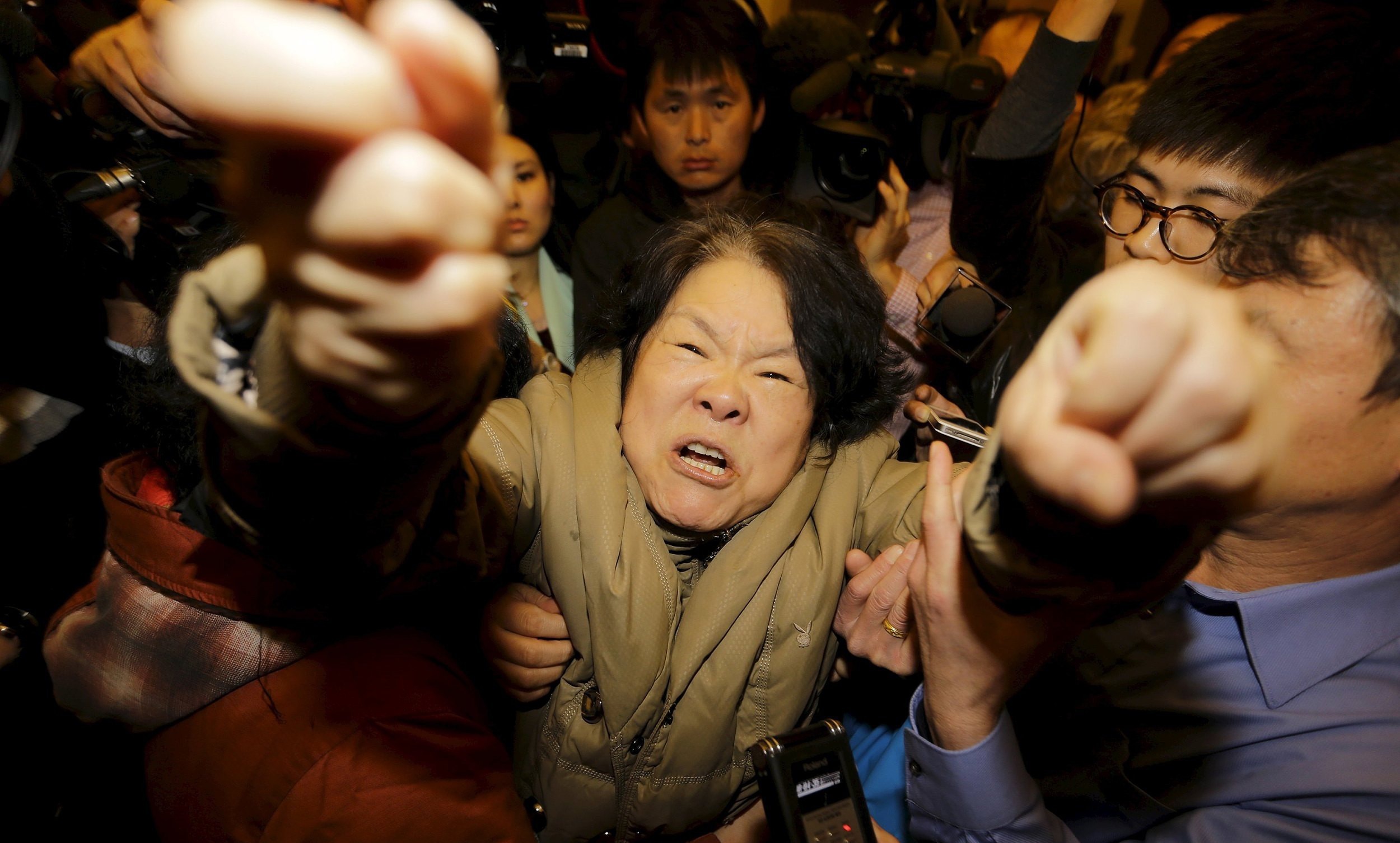 2014年3月24日，北京，一名MH370乘客的家属在收看一场新闻发布会后对记者叫喊。