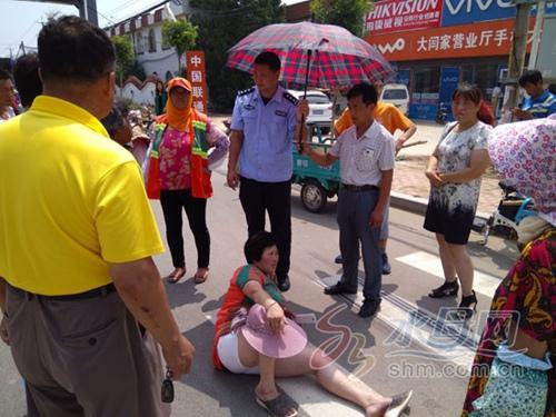 烟台民警为摔伤女子撑伞遮挡烈日 坚持半小时等救助 烟台民警为摔伤女子撑伞遮挡烈日 坚持半小时等救助
