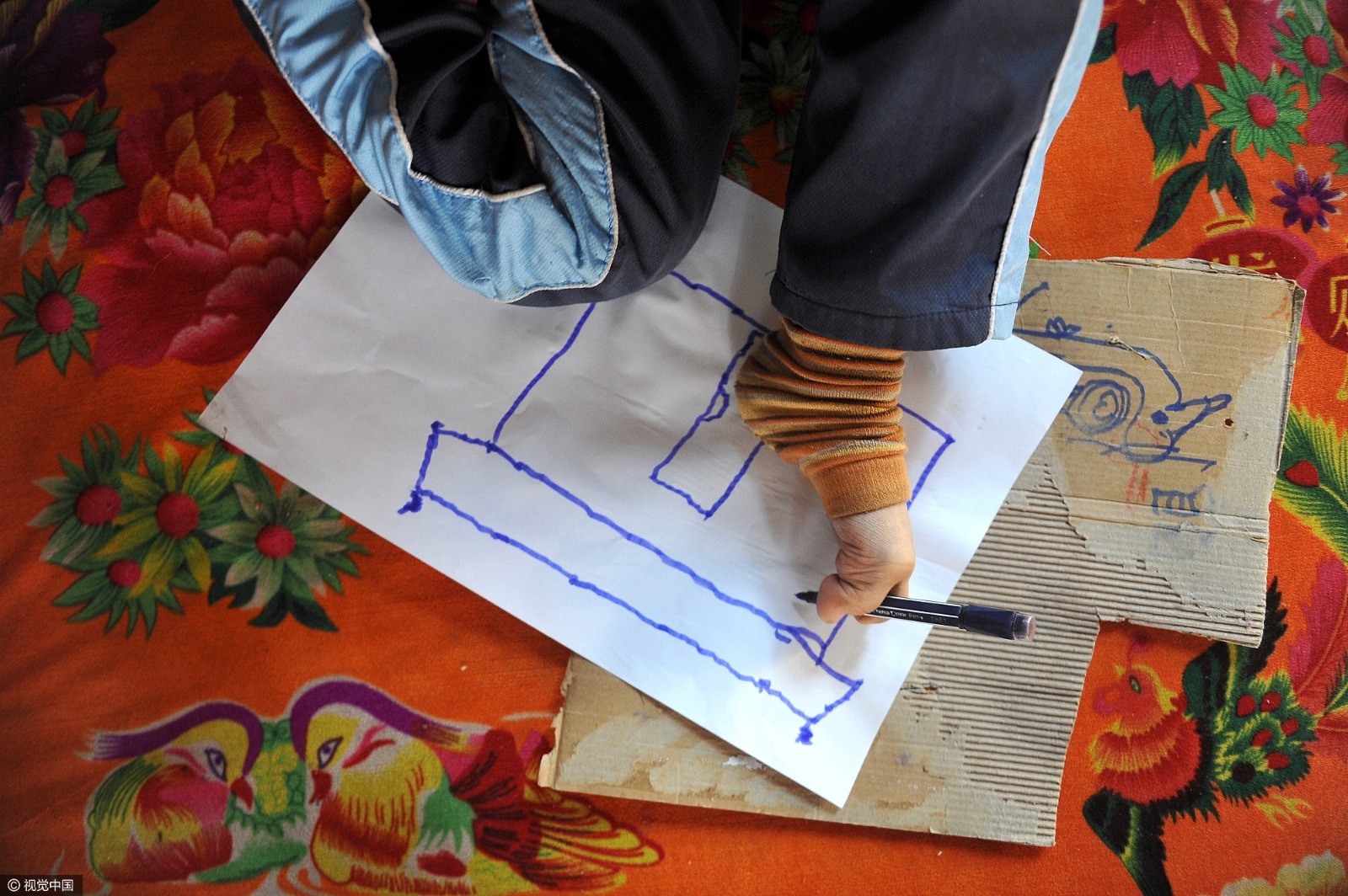 小男孩在用脚画画.