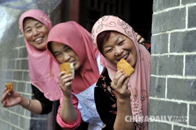 开斋节期间，穆斯林家家户户都要炸油香、馓子、烹调佳肴、宴请宾客等。图为2016年7月6日，在山东省临沂市郯城县马头镇清真寺，穆斯林女性品尝美食。