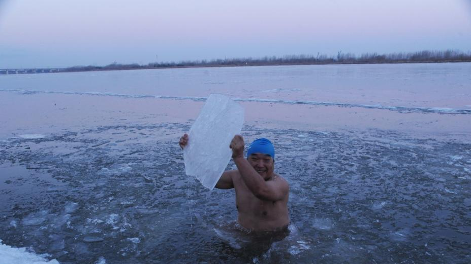 松花江哈尔滨段封江 冬泳爱好者凿冰游泳
