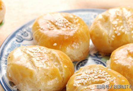 把干油酥包入水油面团内,按扁擀成长方形薄片.