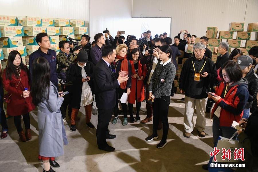10月23日，十九大新闻中心组织前来采访中共十九大的境外记者前往河北省高碑店市、定兴县等探访当地发展情况及其在京津冀协同发展中发挥的作用。图为境外记者探访承接北京新发地功能的河北新发地市场，并在市场内的香蕉储存仓库听取当地工作人员介绍。