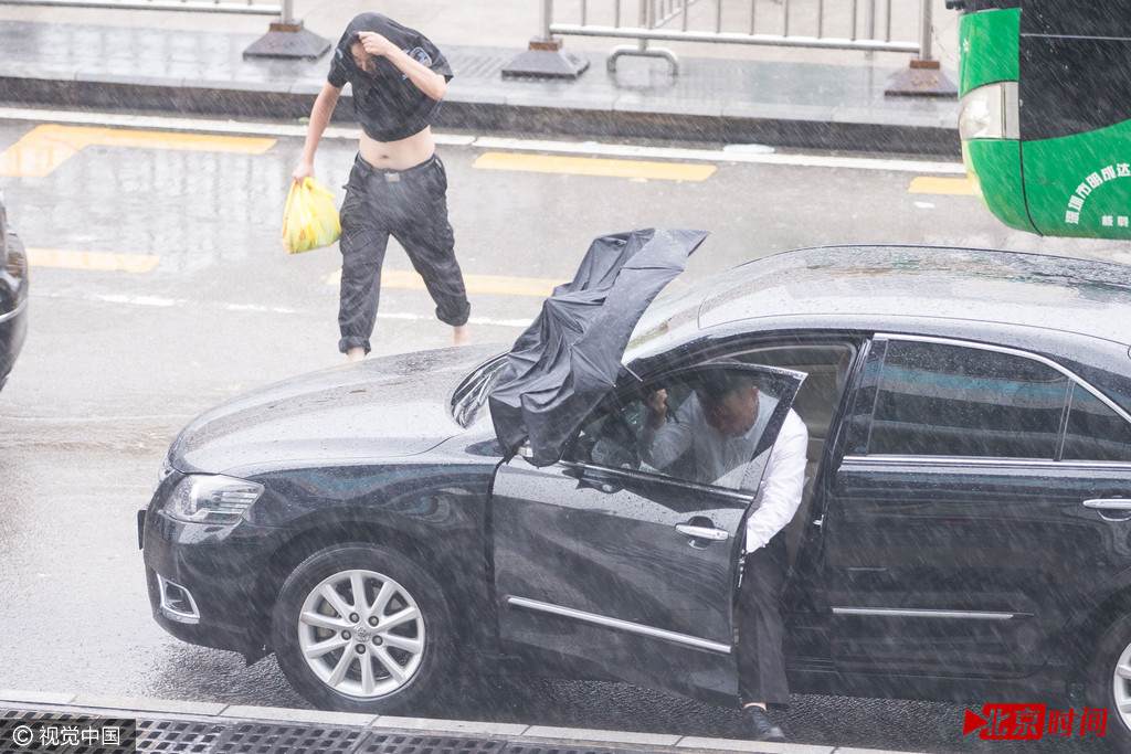 市民未撑伞在台风天冒雨快速前行。
